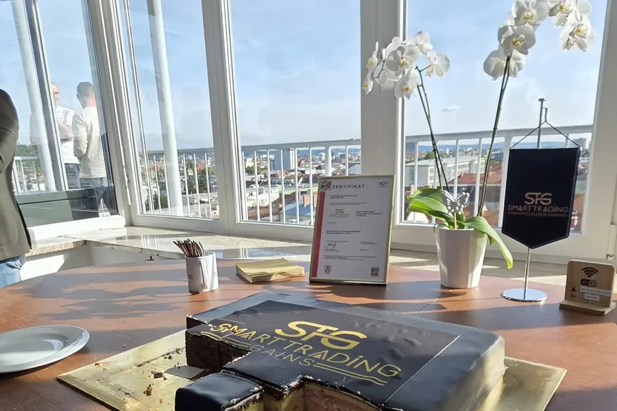 Torte mit dem STG-Logo während des Events, dahinter Zertifikat und Dachterrasse