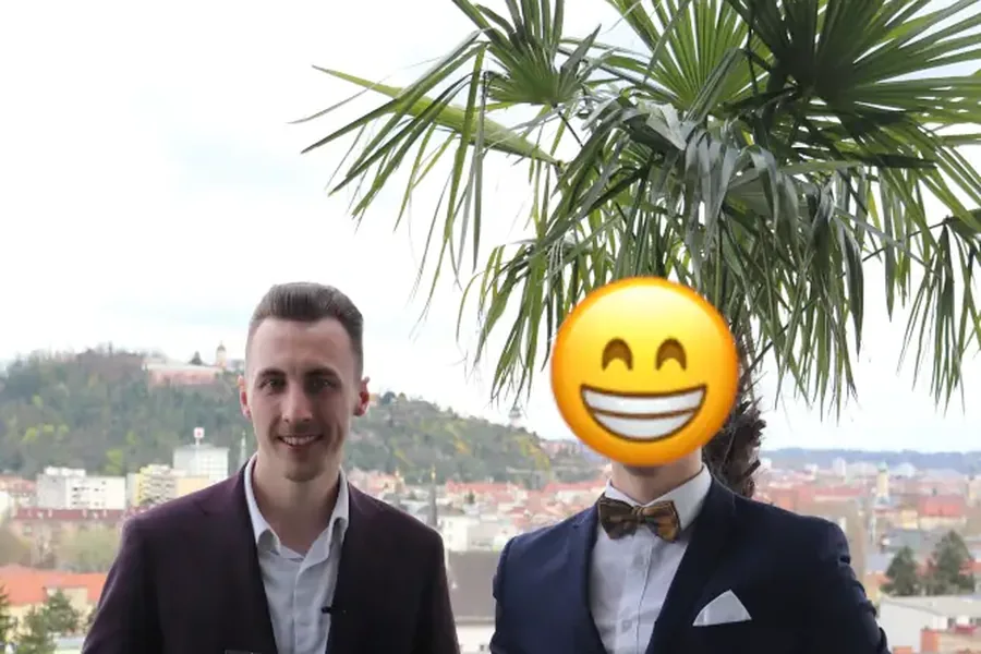 Thomas Wabnig mit einem Teilnehmer auf der Dachterrasse, im Hintergrund der Schloßberg