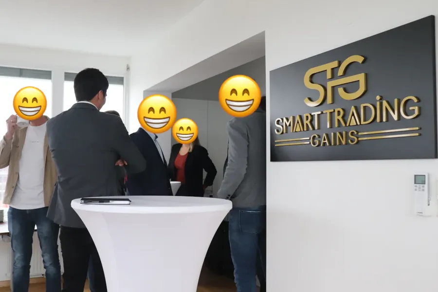 Gespräche an Stehtischen vor dem STG-Schriftzug