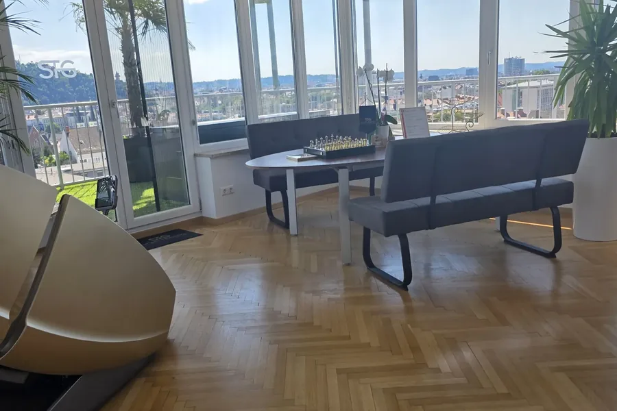 Loft mit langem Tisch und Blick über Graz