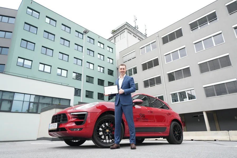 Thomas Wabnig mit dem gerahmten T&Uuml;V-Zertifikat vor dem Firmensitz am Bahnhofg&uuml;rtel